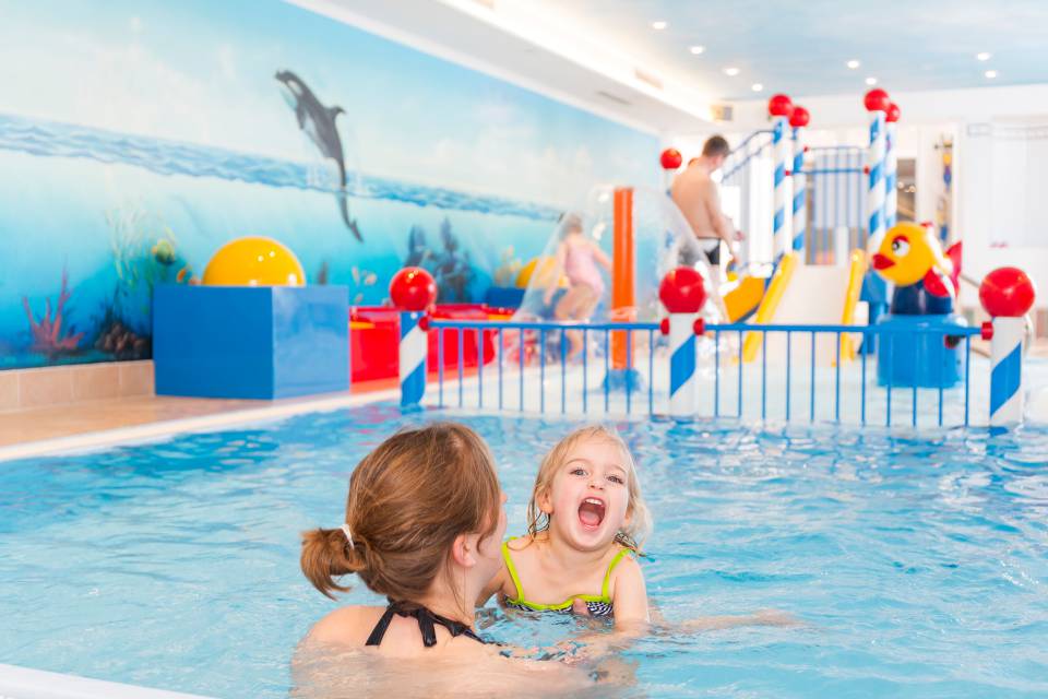 The mother and child are in the children's swimming pool at Familotel Kaiserhof.