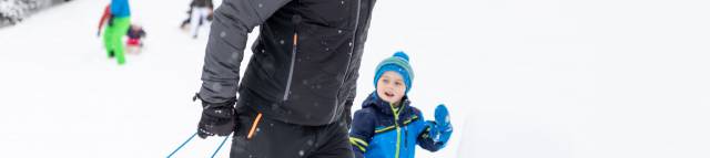 Parents and children play in the snow in Berwang