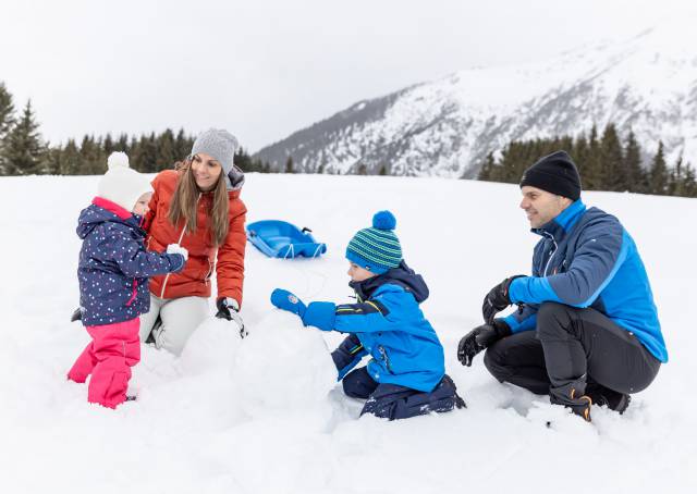 Family builds a snowman in Tyrol