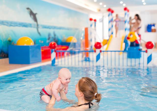 Mother with her baby is schwimming in the pool