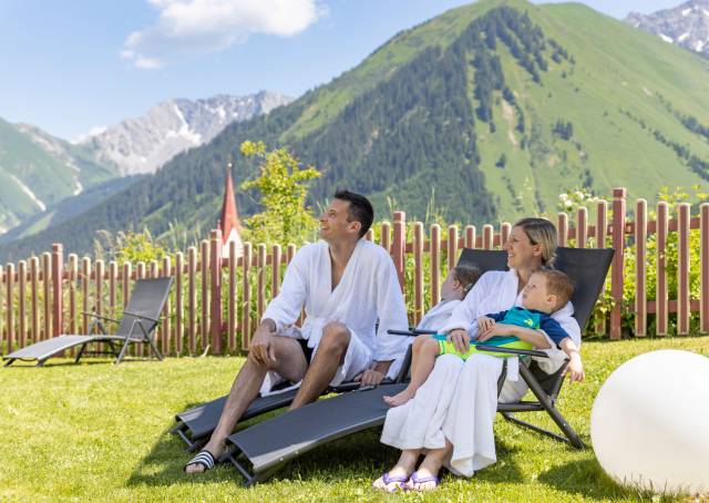 Family is relaxing in the outdoor area with mountain view.