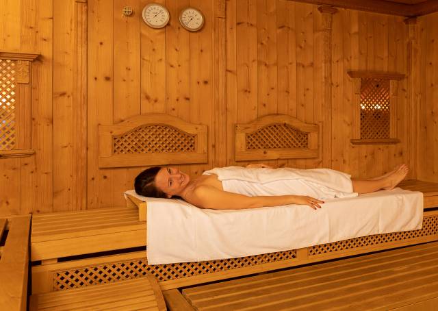 Woman lying in a wooden sauna at the Kaiserhof wellness hotel