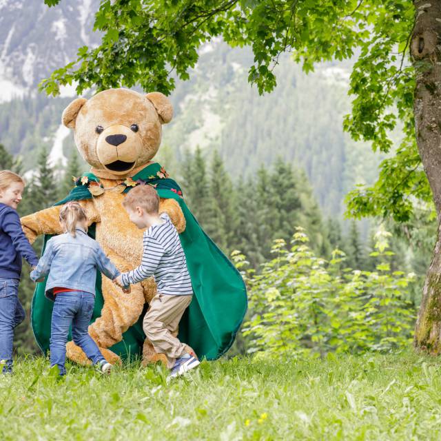 Familotel Kaiserhof mascot plays with children on a meadow