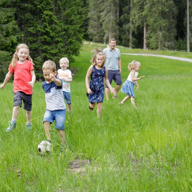 Children playing soccer on a green field