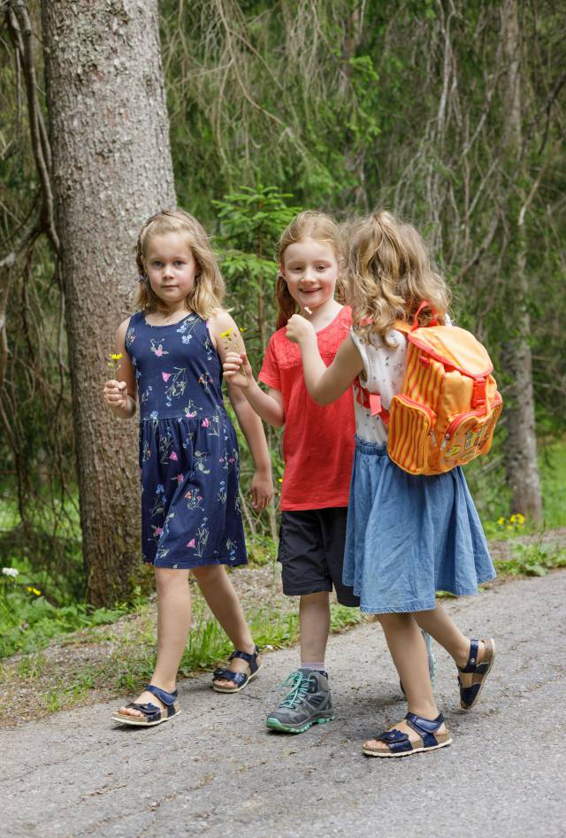 Three girls walk along the street