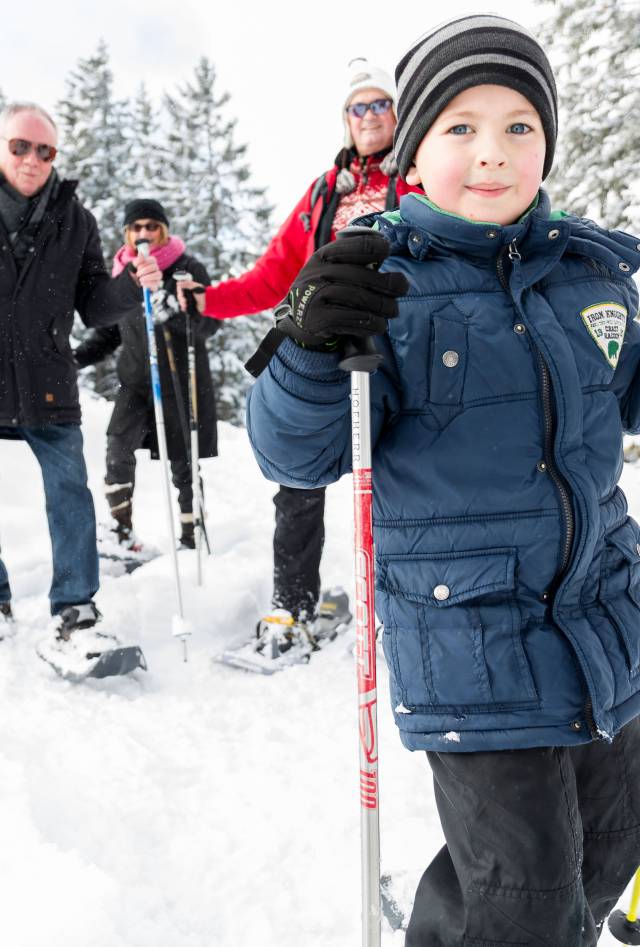 Family with child and grandparents snowshoeing in Tyrol