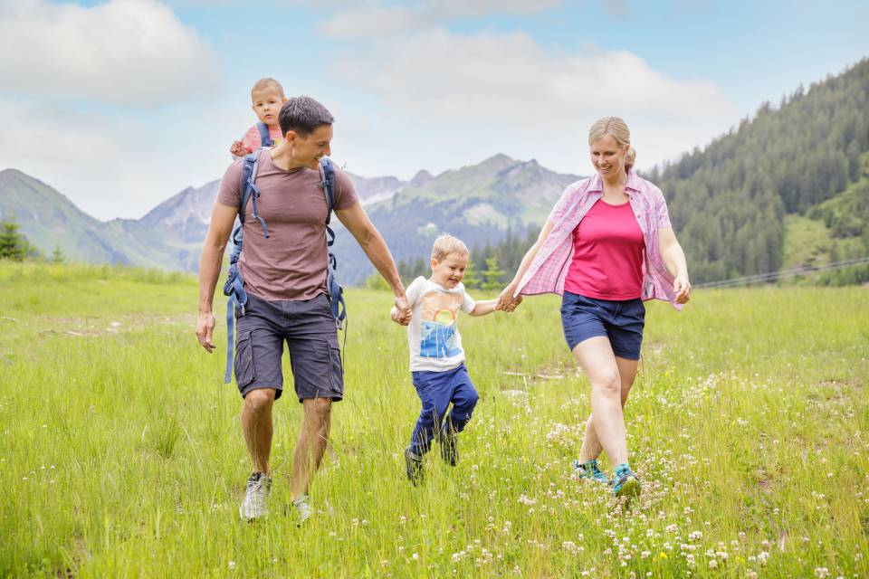 Family runs across meadow in Tyrol