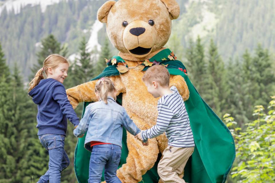 Familotel Kaiserhof mascot plays with children on a meadow