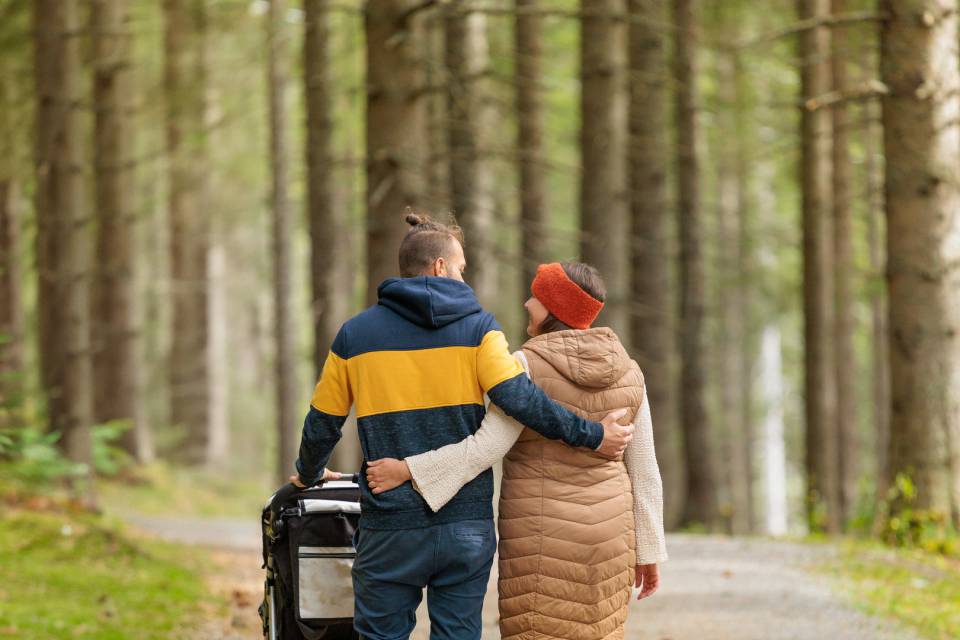 Mama und Papa auf einem Waldspaziergang in Berwang mit Kinderwagen