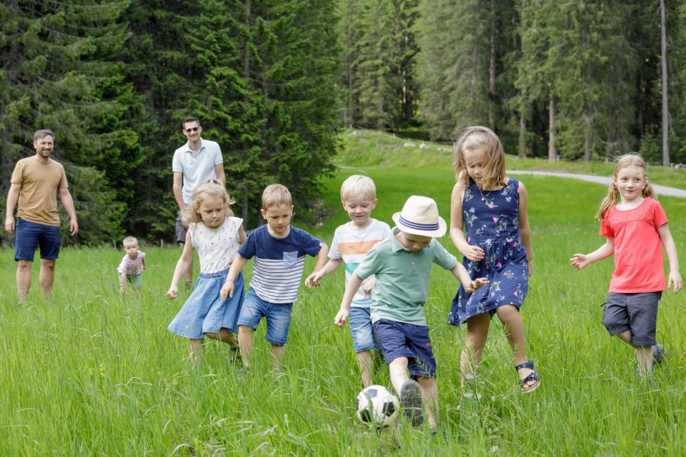 Kinder spielen Fußball auf der Wiese nahe dem Familotel Kaiserhof in Tirol