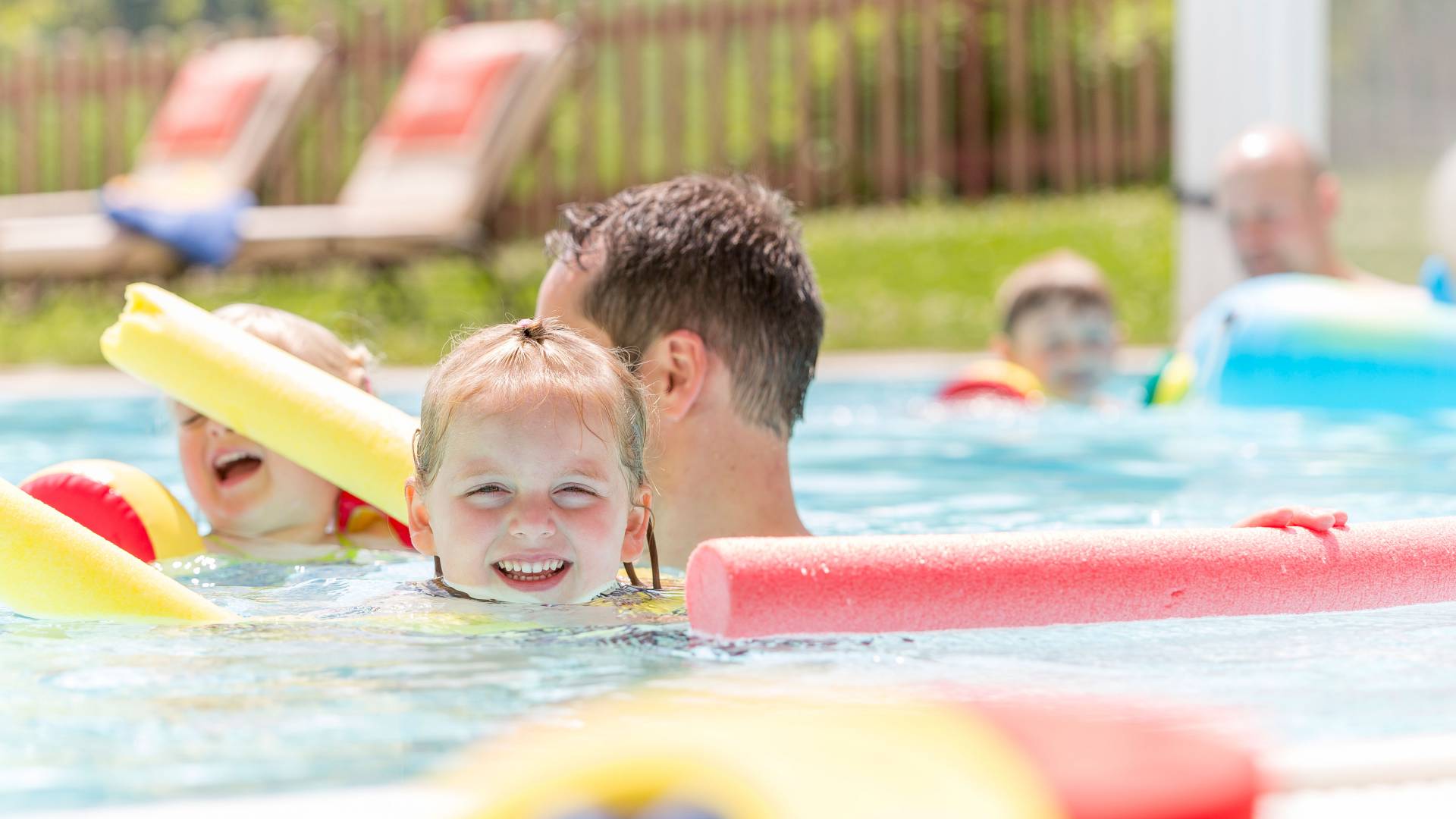 Toddlers wirh their parents in the pool