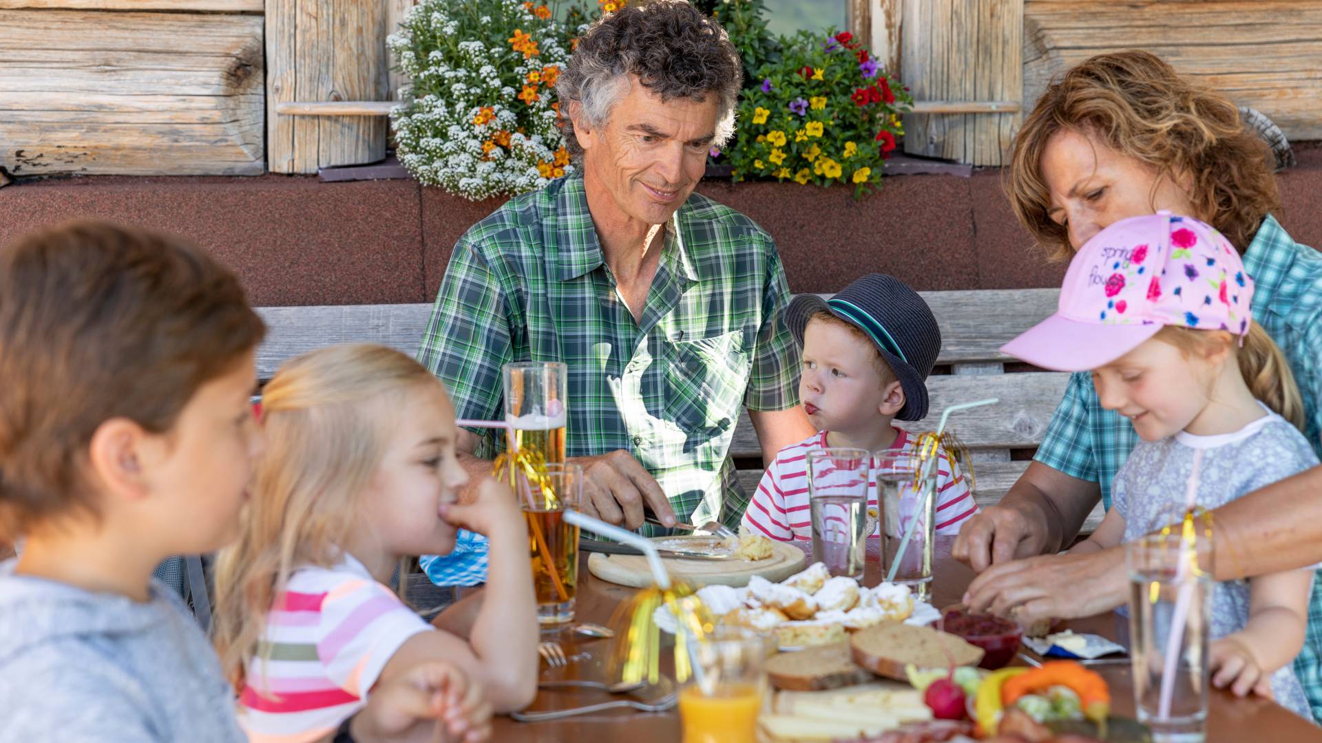 Children eat with grandparents in an alpine hut